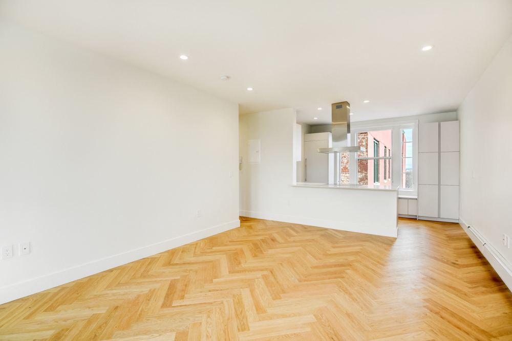 a living room with a hardwood floor and white walls